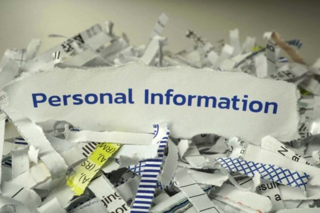 a pile of torn paper with a sign that says personal information.